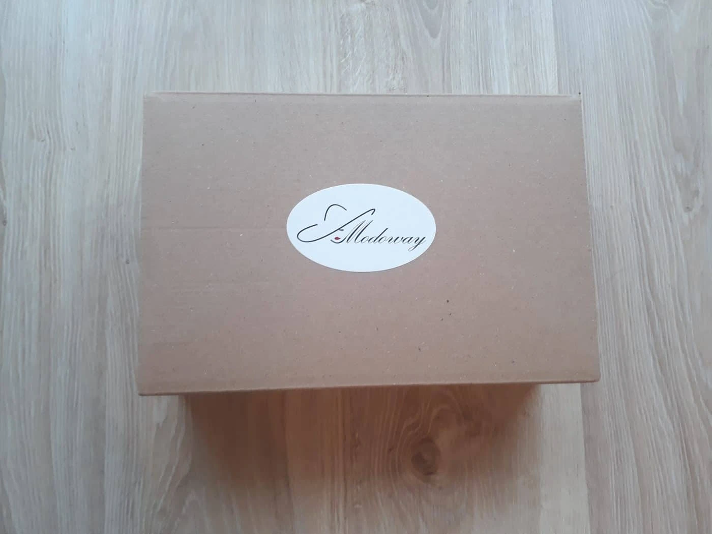 naklejka przyklejona na paczkę z logo Modoway