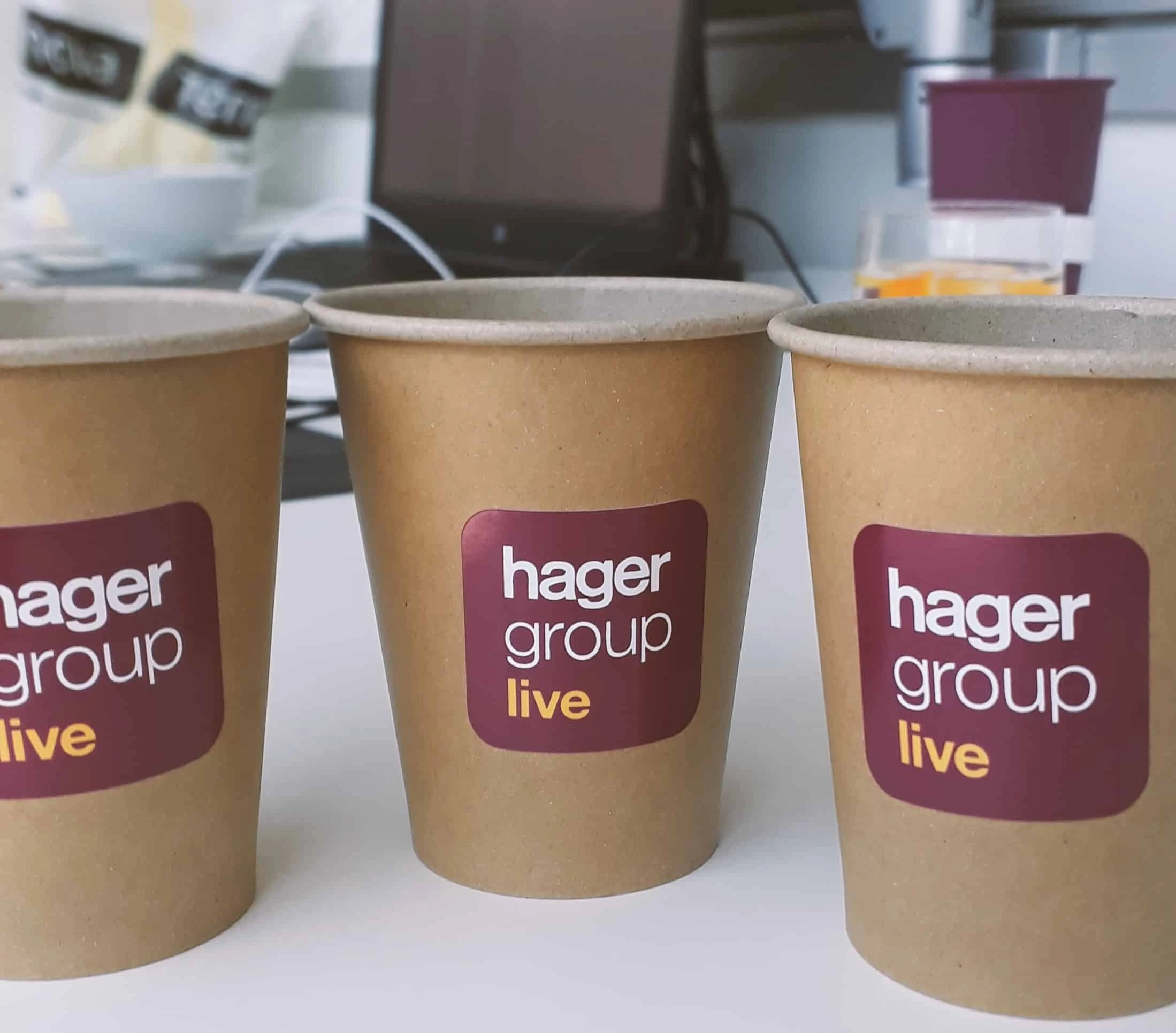 naklejki z napisem "hager group live" przyklejone na kubek