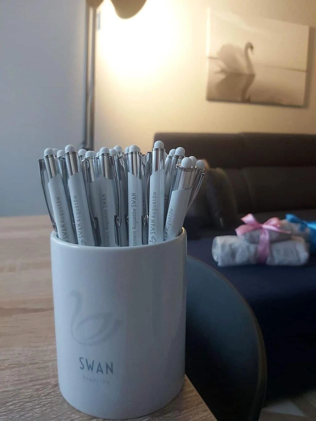 długopisy reklamowe z logo SWAN Augustów umieszczone w kubku