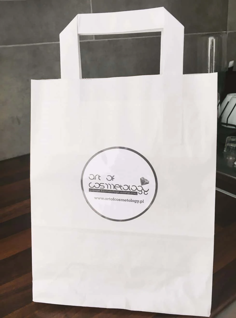 naklejka reklamowa przyklejona na torbie z logo art of cosmetology
