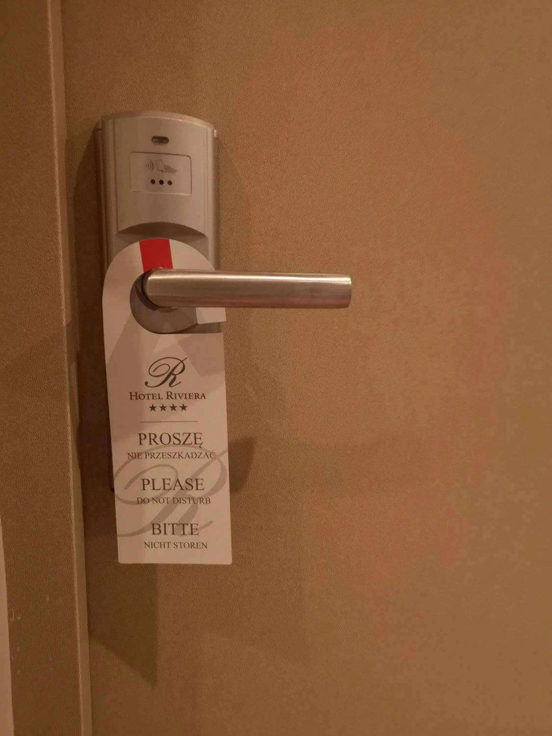 zawieszka z logo hotelu Riviera zawieszona na klamce drzwi