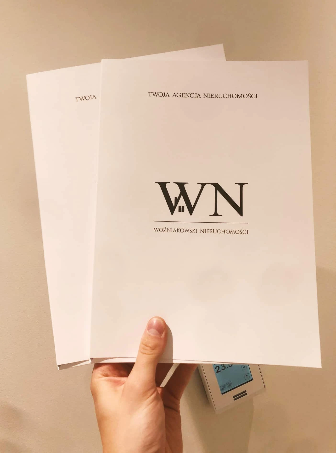 teczki ofertowe z logo Woźniakowski Nieruchomości