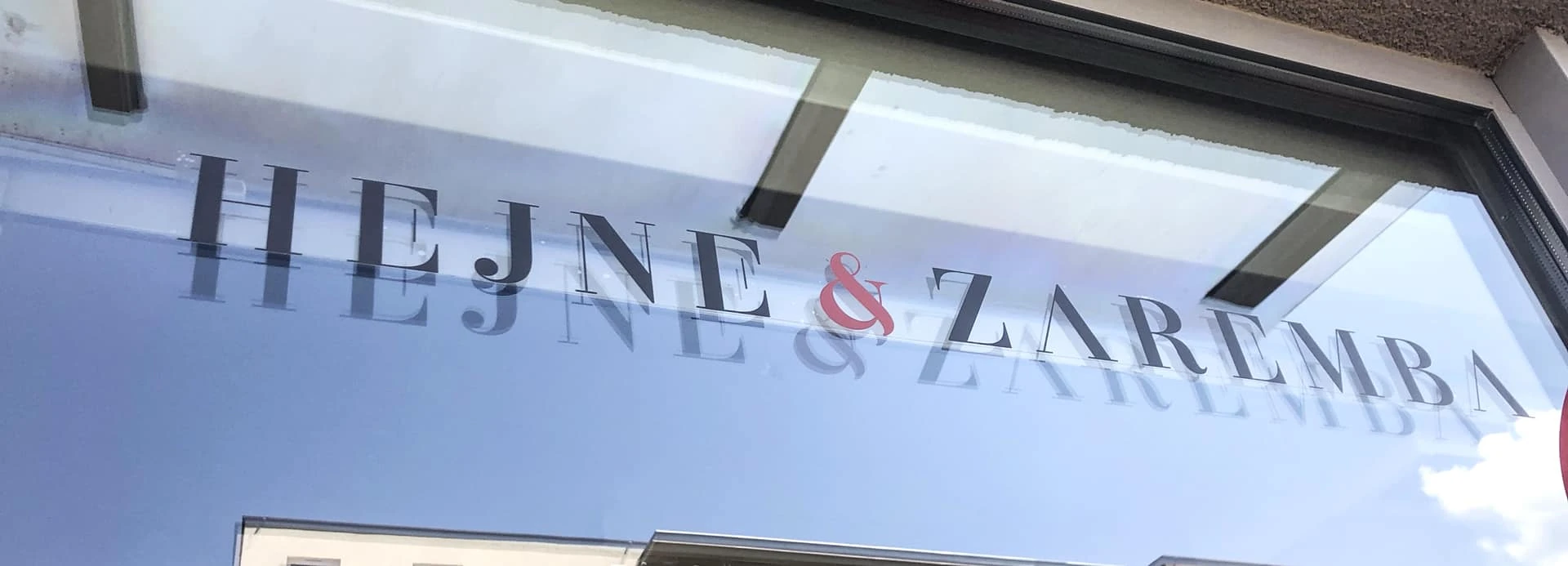 naklejka przeżroczysta przyklejona z napisem Hejne & Zaremba