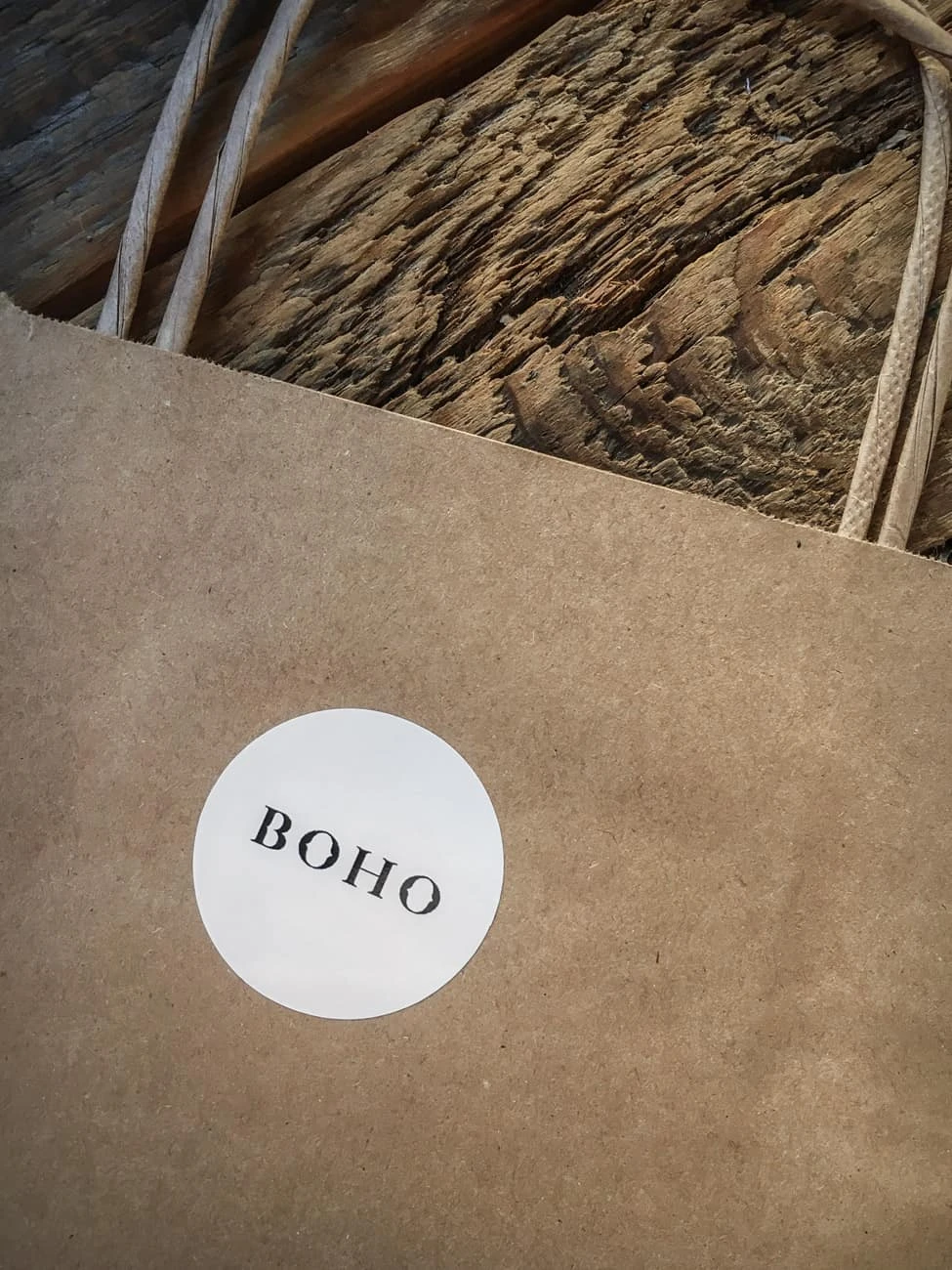 zdjęcie naklejek z logo BOHO przyklejonych na papierowe torby